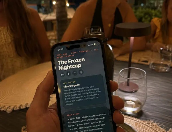 A phone held over a table, its screen showing The Frozen Nightcap case briefing mid-game.