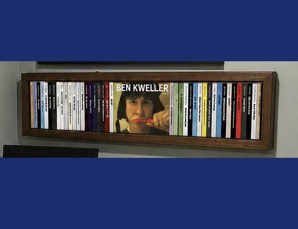 A framed, wall-mounted bar of generated CD spines, the Ben Kweller spine pulled open to show its cover.